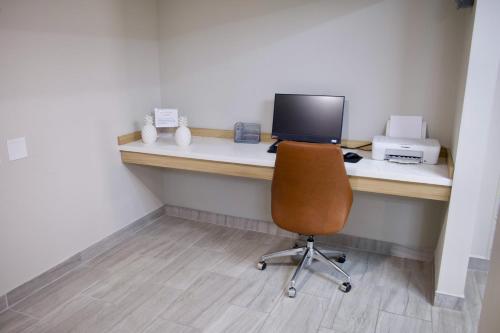 an office with a desk with a computer and a chair at Candlewood Suites Harrisonburg by IHG in Harrisonburg
