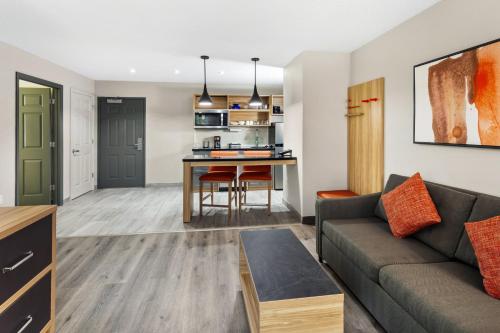 a living room with a couch and a kitchen at Candlewood Suites Harrisonburg by IHG in Harrisonburg