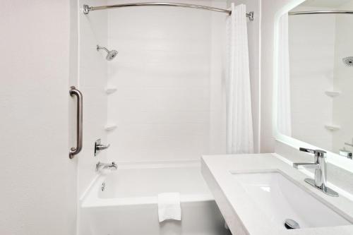a white bathroom with a sink and a mirror at Candlewood Suites Harrisonburg by IHG in Harrisonburg