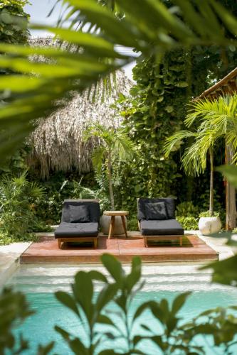 two chairs and a table next to a pool at Colonte Hotel Origen in Valladolid