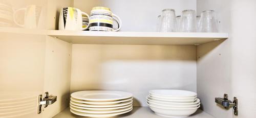 dos pilas de platos en una despensa de cocina en Elite Residence, en Accra
