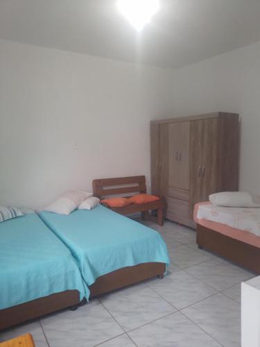 a bedroom with two beds and a cabinet in it at Simplesmente aconchegante in Itapoa