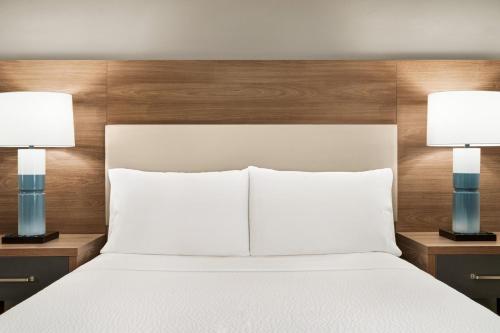 a bedroom with a white bed with two lamps at Candlewood Suites Boise - Towne Square by IHG in Boise
