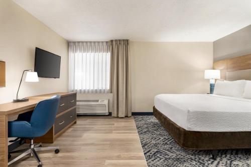 a hotel room with a bed and a desk and a computer at Candlewood Suites Boise - Towne Square by IHG in Boise