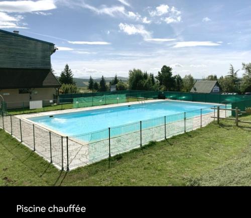 une grande piscine entourée d'une clôture. dans l'établissement App 2 chambres SuperBesse 35m2 4 à 6 personnes proches Lacs et commerces, à Besse-et-Saint-Anastaise
