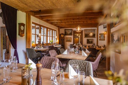 a restaurant with wooden tables and chairs and windows at Hotel-Restaurant Eifeler Seehütte in Rieden