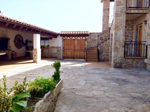 a courtyard of a house with a wooden gate at El Desván del Trigo in El Barraco