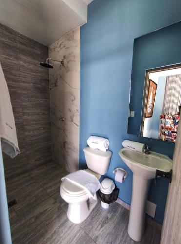 a blue bathroom with a toilet and a sink at Hotel Panorama 1947 in El Banco