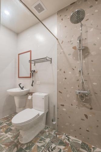 a bathroom with a toilet and a rock wall at 苒得出門 - 台南包棟民宿 in Tainan