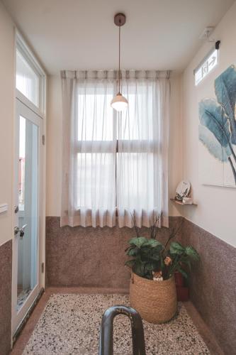 a bathroom with a window and a sink with a plant at 苒得出門 - 台南包棟民宿 in Tainan