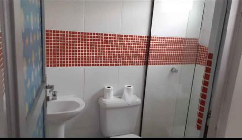 a bathroom with a toilet and a sink at Recanto das borboletas in Matinhos