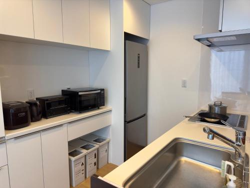 a kitchen with a sink and a microwave at n6天花 in Niseko