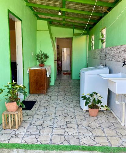 a green room with a bathroom with a sink at Casa Privativa com Varanda Gourmet e Churrasqueira- Pet Friendly- Wi-Fi e Garagem in Imbituba