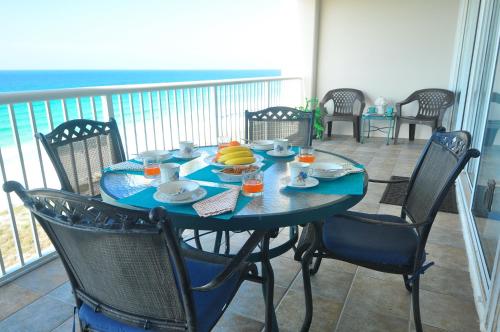 a blue table with chairs and food on a balcony at Paradise Found Direct Gulf Front 2 bedroom Condo in Navarre