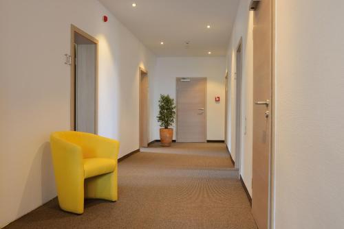 a hallway with a yellow chair in an office at Hotel Kiekenstein in Stahle