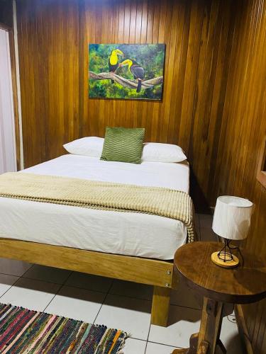 a bedroom with a bed and a table with a lamp at Casa 1856- cómodas habitaciones en el Centro de Alajuela in Alajuela City