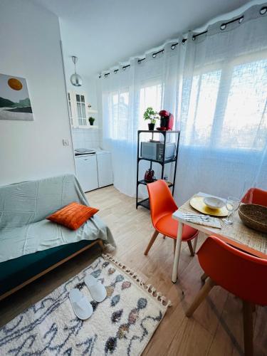 a living room with a couch and a table at Le Cocon Autonome - A 10 min de Paris in Houilles