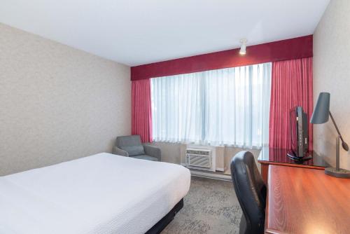 a hotel room with a bed and a window at Sandman Hotel Penticton in Penticton