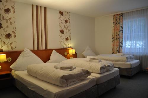 アルテンアウにあるHotel Engel Altenauのベッド2台と窓が備わるホテルルームです。
