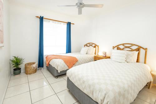 Cairns NorthにあるElevated 2BR Modern Furnished Terrace Apartmentの窓のある部屋にベッドが2つある