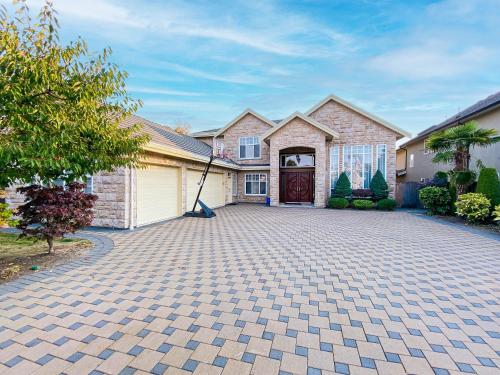 a brick house with a driveway in front of it at Close to YVR King Sized Private Entrance Suite in Richmond