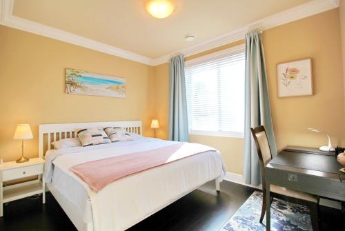 a bedroom with a bed and a desk and a window at Close to YVR King Sized Private Entrance Suite in Richmond