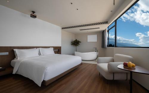 a bedroom with a white bed and a large window at Neo-garden in Dali