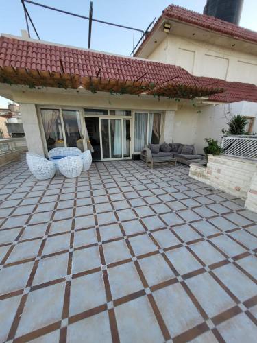 a patio with two chairs and a house at شقه فى ميامى بالاسكندريه مطله على البحر in Alexandria
