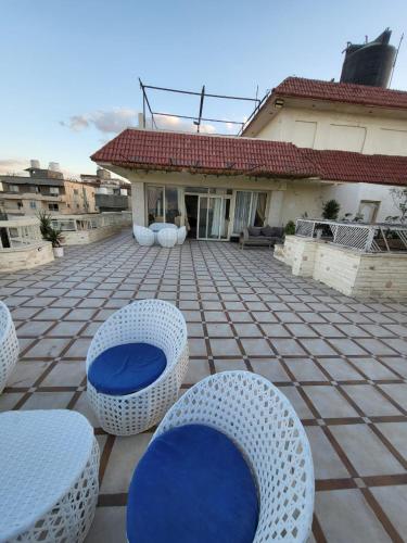 a patio with blue chairs and a house at شقه فى ميامى بالاسكندريه مطله على البحر in Alexandria