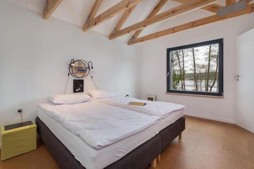 un grand lit dans une chambre avec une fenêtre dans l'établissement Holiday Home by Lake Wise ka, Near Baltic Beach, à Wisełka