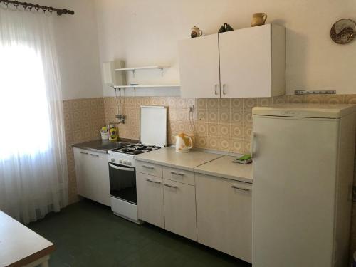 una cucina con armadietti bianchi, piano cottura e frigorifero di Apartments by the sea Drasnice, Makarska - 23448 a Drašnice