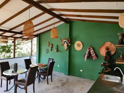 a dining room with green walls and a table and chairs at Finca Villa Laura in Támesis