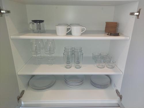 a white shelf with glasses and plates on it at n6天花 in Niseko