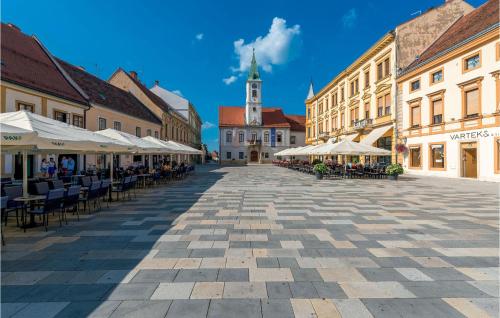 a city street with tables and chairs and a clock tower at Holiday Home Noah in Leštakovec