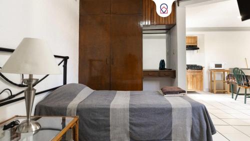 a bedroom with a bed and a table with a lamp at Bohemian Loft Xochimilco Neighborhood - 1 Bed in Oaxaca City