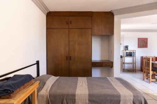 a bedroom with a bed and a wooden cabinet at Bohemian Loft Xochimilco Neighborhood - 1 Bed in Oaxaca City