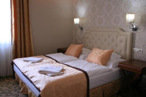 a hotel room with a bed with towels on it at Golden Ball Club in Győr