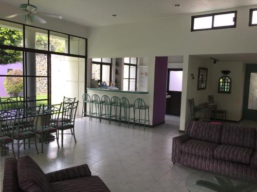 a living room with a couch and a table and chairs at CASA MORADA 24 Personas alberca climatizada Burgos Cuernavaca in Cuernavaca