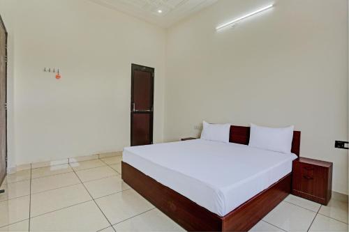 a bedroom with a large white bed in a room at Super Hotel O Park Inn Near Parashuram Chowk in Morādābād
