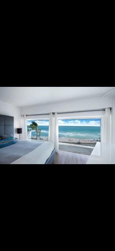 a bedroom with a large window with a view of the ocean at Luxury - Ocean front - 3 Bedroom 2 Bathroom - Penthouse in Miami Beach