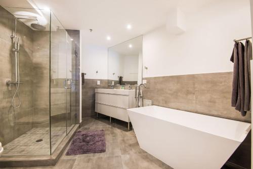 a bathroom with a large white tub and a shower at Luxury - Ocean front - 3 Bedroom 2 Bathroom - Penthouse in Miami Beach