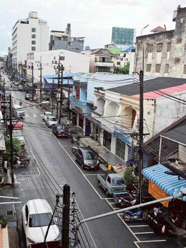 a city street with cars parked on the street at Moon's House Hatyai มูนเฮ้าส์ หาดใหญ่ in Hat Yai