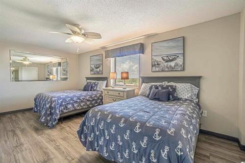 a bedroom with two beds and a ceiling fan at Seas The Day - Stunning Ocean Views, Direct Beach Access, Prime Location! in Myrtle Beach