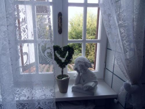 a statue sitting on a window sill next to a plant at Cuore Verde in Cavour