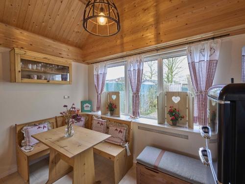 a dining room with a table and some windows at Landsraderhöfke - 4 in Heijenrath