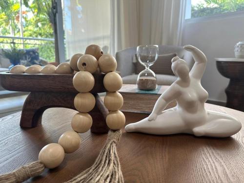 a wooden table with a figurine of a woman sitting on a table at Luxury 2 Bedroom Apartment, 1 Min Walk to Punta Popy Beach, Pool, AC, Fast WiFi, Las Terrenas in Las Terrenas