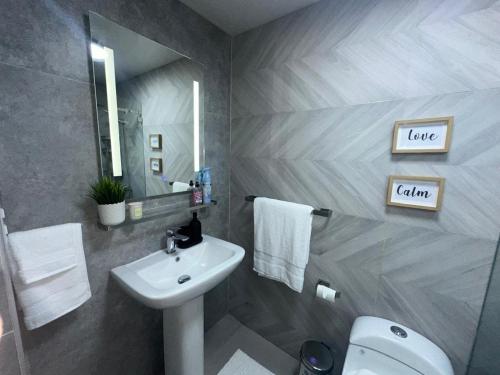 a bathroom with a sink and a toilet and a mirror at Luxury 2 Bedroom Apartment, 1 Min Walk to Punta Popy Beach, Pool, AC, Fast WiFi, Las Terrenas in Las Terrenas