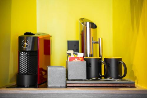 a shelf with cups and other items on a yellow wall at SUN & MOON, Riverside Hotel in Phnom Penh