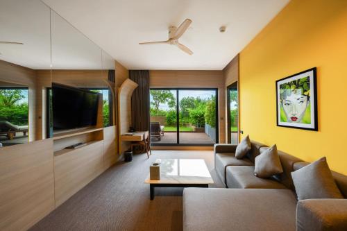 a living room with a couch and a tv at SUN & MOON, Riverside Hotel in Phnom Penh