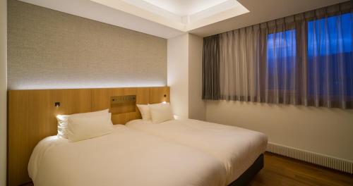 Giường trong phòng chung tại HOTEL LA VIGNE HAKUBA by Onko Chishin
